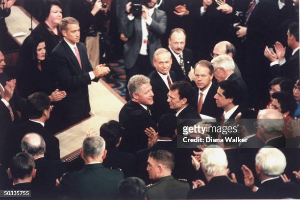 Pres. Bill Clinton embracing Sen. Tom Daschle in crowd during State of Union address to Joint Session of Congress amid allegations of sexual scandal...