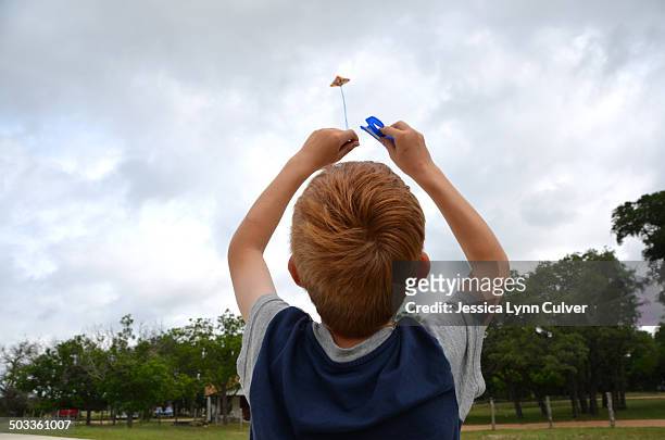 ginger hair boy flying a kite on a cloudy day - ginger lynn allen stockfoto's en -beelden