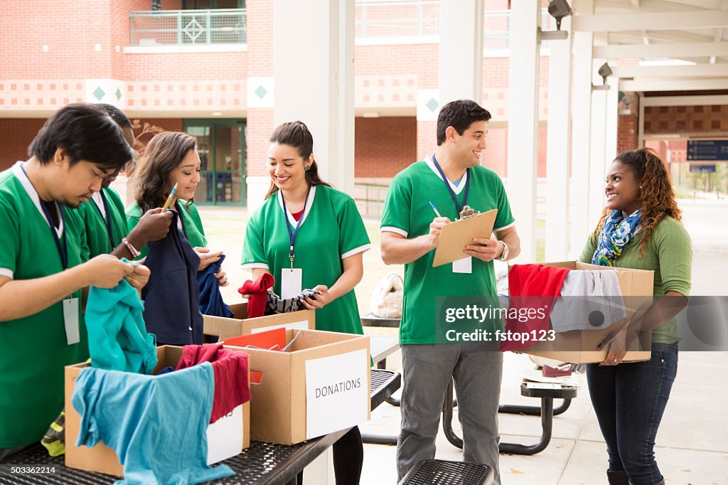 Group of college student volunteers collect clothing donations. Charity.