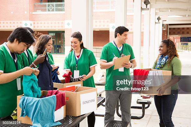 group of college student volunteers collect clothing donations. charity. - emergency management stock pictures, royalty-free photos & images