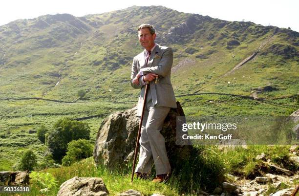 Britain's Prince Charles holding a can while leaning against a rock during a visit to the Hafod y Llan estate.