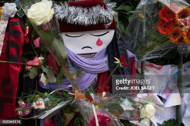 Doll crying is seen among flowers at a makeshift memorial in tribute to the victims of the Paris terror attacks, on January 4 outside the Bataclan...