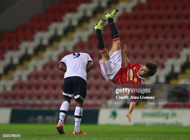 Ben Pearson of Manchester United U21 falls over Shaquile Coulthirst of Tottenham Hotspur U21 after competing for a high ball during the Barclays U21...