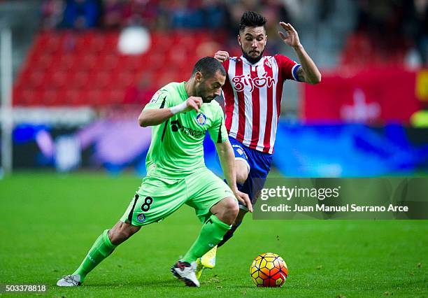 Miguel Guerrero of Real Sporting de Gijon duels for the ball with Mehdi Lacen of Getafe CF during the La Liga match between Real Sporting de Gijon...