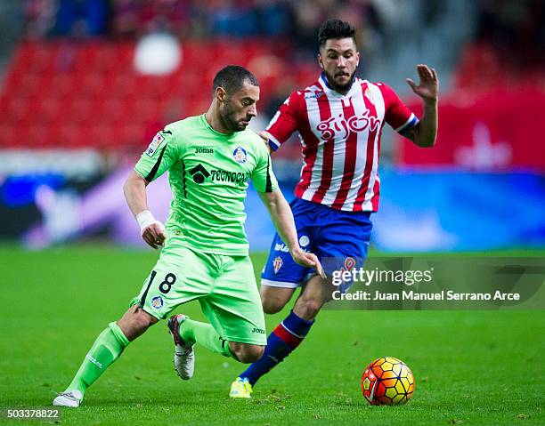 Miguel Guerrero of Real Sporting de Gijon duels for the ball with Mehdi Lacen of Getafe CF during the La Liga match between Real Sporting de Gijon...