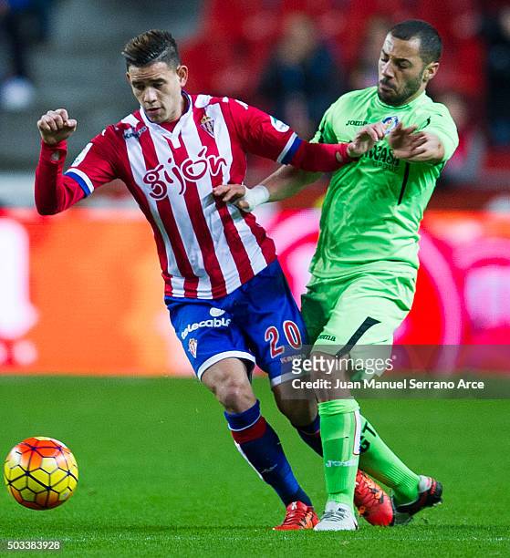 Arnaldo Sanabria of Real Sporting de Gijon duels for the ball with Mehdi Lacen of Getafe CF during the La Liga match between Real Sporting de Gijon...