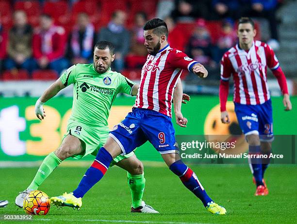 Miguel Guerrero of Real Sporting de Gijon duels for the ball with Mehdi Lacen of Getafe CF during the La Liga match between Real Sporting de Gijon...