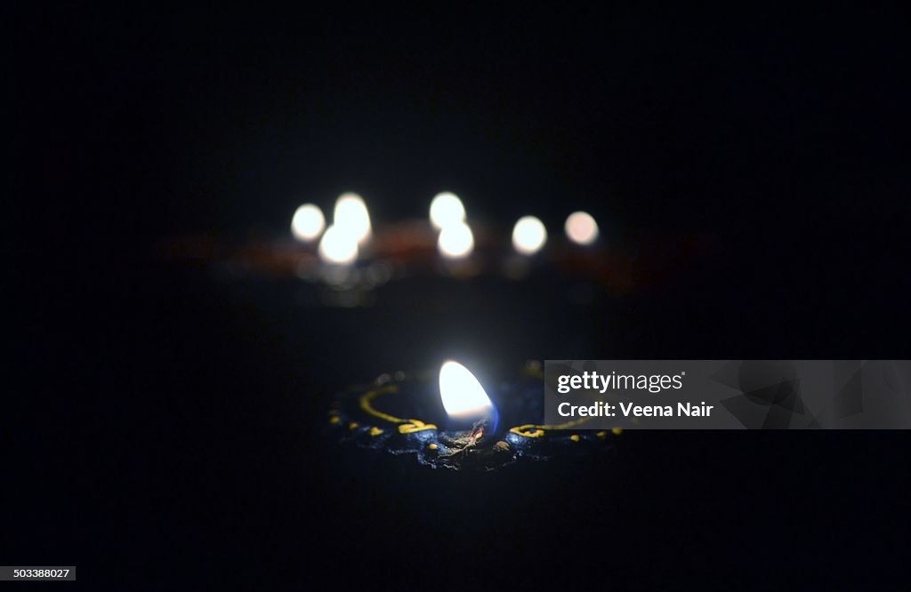 Lighted clay Diwali diya with bokeh