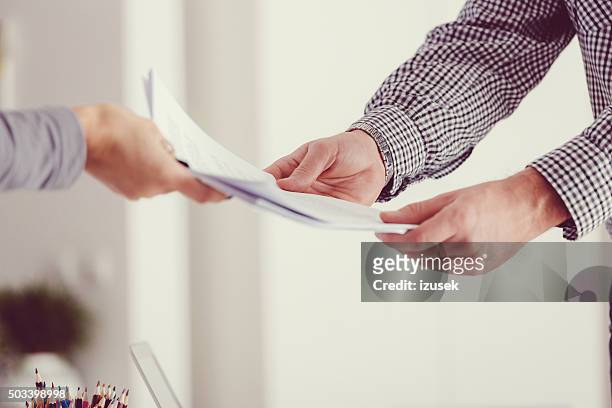 people holding documents, close up of hands - geven stockfoto's en -beelden