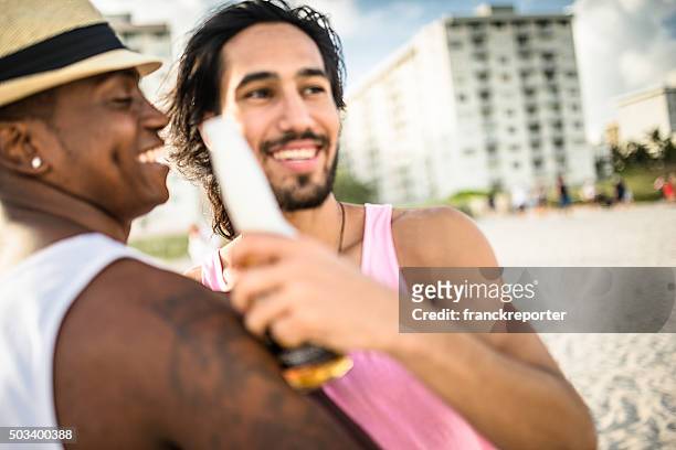 men drinking beers at the party beach in miami - miami party stock pictures, royalty-free photos & images