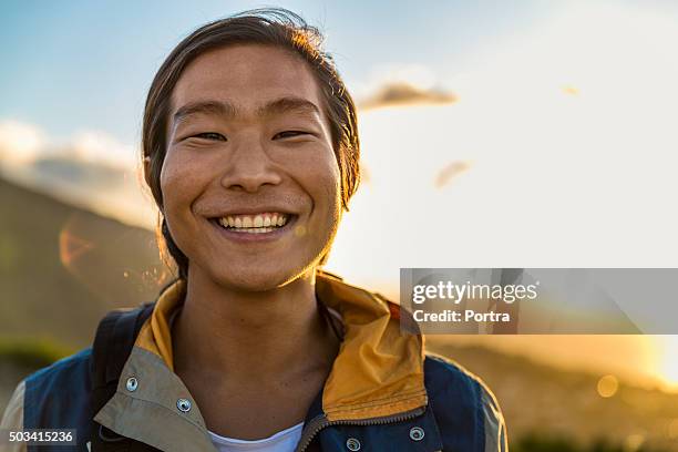 smiling male backpacker on hill during sunset - young male hiker stock pictures, royalty-free photos & images