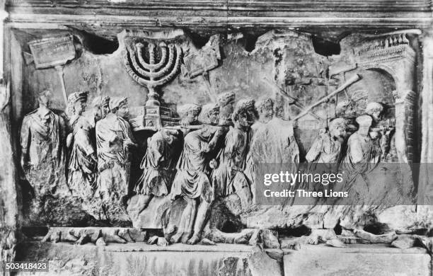 Relief from the Arch of Titus in Rome Italy, photographed circa 1955. The carving depicts spoils, including the Menorah and the trumpets of Jericho,...