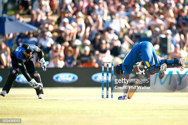 Angelo Mathews of Sri Lanka trips over as wicket keeper Luke Ronchi of New Zealand looks on during game five of the One Day International series...