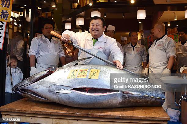 President of sushi restaurant chain Sushi-Zanmai, Kiyoshi Kimura holds a long fish knife as he poses with a 200-kilogram bluefin tuna at his main...