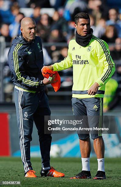 Newly appointed manager of Real Madrid Zinedine Zidane hands a bib to Cristiano Ronaldo during a Real Madrid training session at Valdebebas training...