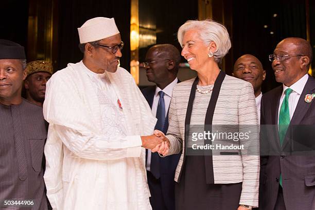 In this handout image provided by the International Monetary Fund, International Monetary Fund Managing Director Christine Lagarde shakes hands with...
