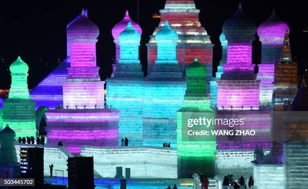 Visitors walk through the China Ice and Snow World during the Harbin International Ice and Snow Festival in Harbin, northeast China's Heilongjiang...