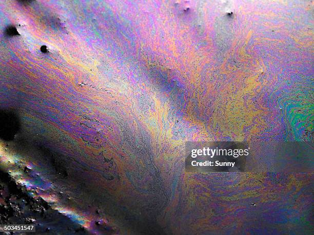oil patterns on water - environmental damage foto e immagini stock