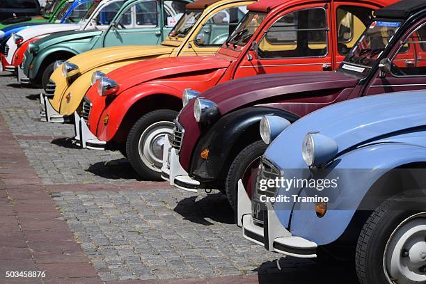 classic citroen 2cv cars in a row on the street - deux chevaux stock pictures, royalty-free photos & images