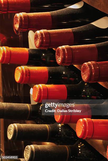 detail of dusty wine bottles in wine cellar - wine bottle stock pictures, royalty-free photos & images