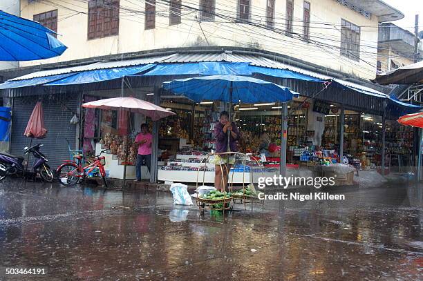 Monsoon rain pours down Street vendor Nong Khai Isaan Thailand