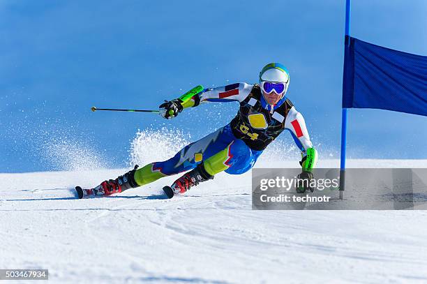 young man compeeting at giant slalom race - alpineskiën stockfoto's en -beelden