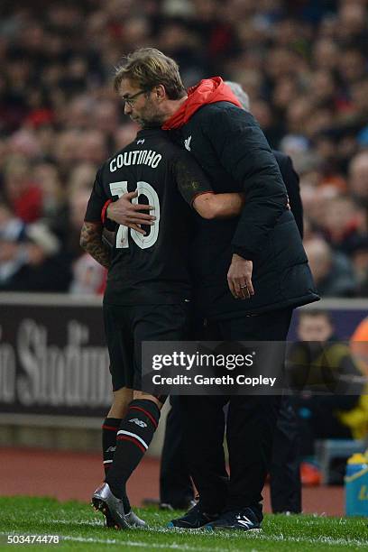 The injured Philippe Coutinho of Liverpool is hugged by Jurgen Klopp the Manager of Liverpool as leaves the pitch due to injury during the Capital...