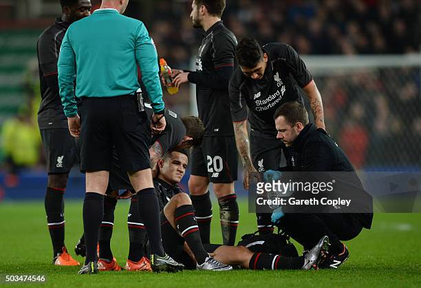 Philippe Coutinho of Liverpool receives treatment before leaving the pitch due to the injury during the Capital One Cup semi final, first leg match...
