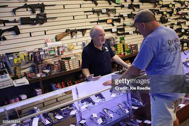 William Gordon, , helps Mark O'Connor as he shops for a handgun at the K&W Gunworks store on the day that U.S. President Barack Obama in Washington,...