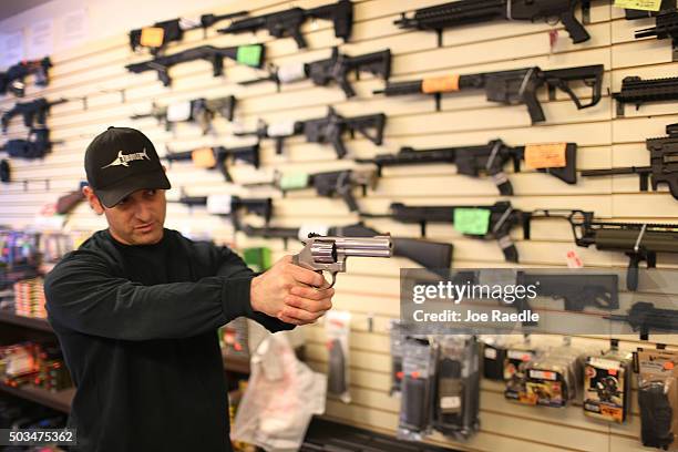 Brandon Wexler shows a customer one of the weapons that she was picking up at the end of the three day waiting period at the K&W Gunworks store on...