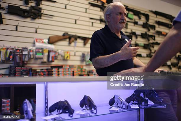 William Gordon helps a customer shop for a handgun at the K&W Gunworks store on the day that U.S. President Barack Obama in Washington, DC announced...