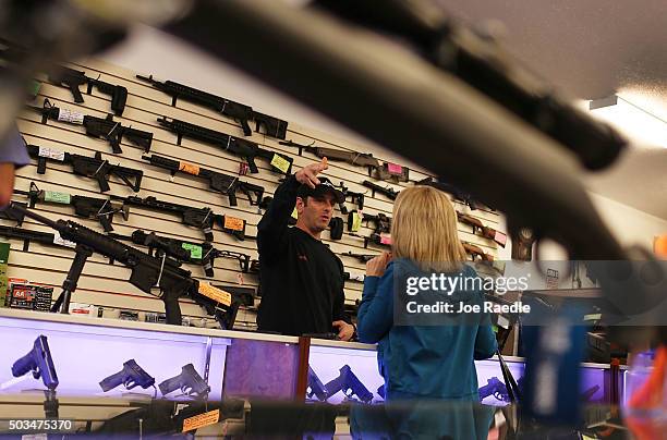 Brandon Wexler helps a customer as she picks up her handguns at the end of the three day waiting period at the K&W Gunworks store on the day that...