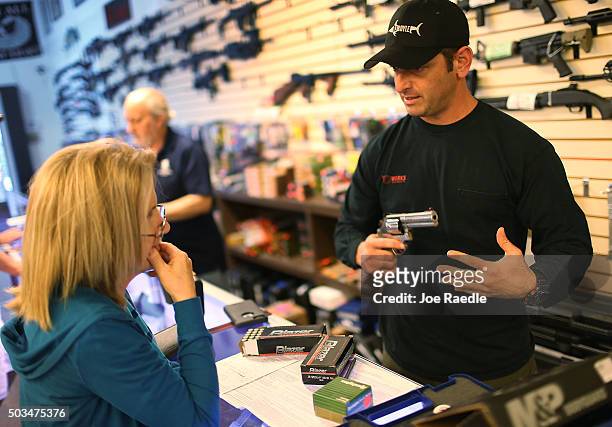 Brandon Wexler shows Cindy Schneider the weapons that she was picking up at the end of the three day waiting period at the K&W Gunworks store on the...