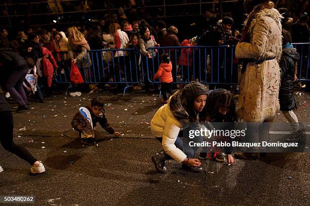 Child collect sweets from the ground after the 'Cabalgata de Reyes,' or the Three Kings parade passed by on January 5, 2016 in Madrid, Spain. The...