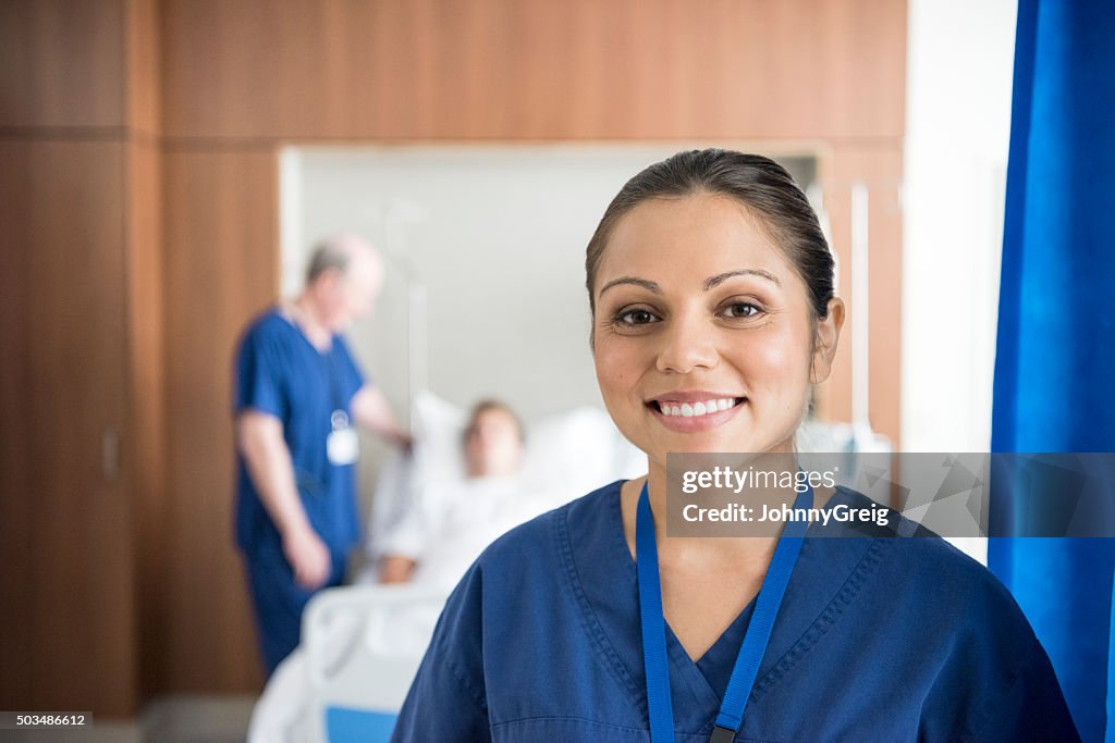 Ethnischen Krankenschwester auf hospital ward lächelnd in die Kamera, Porträt