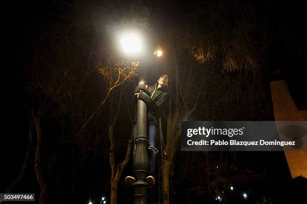 Child climbs to a lamp post to watch the 'Cabalgata de Reyes,' or the Three Kings parade on January 5, 2016 in Madrid, Spain. The traditional parade...
