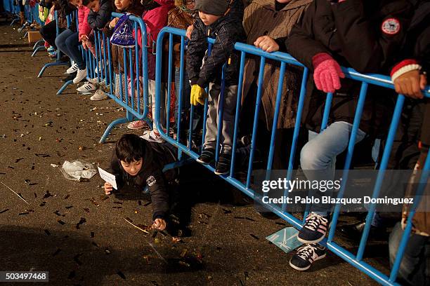 Child collects sweets from the ground during the 'Cabalgata de Reyes,' or the Three Kings parade on January 5, 2016 in Madrid, Spain. The traditional...