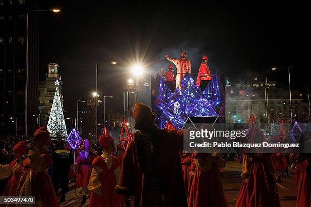 Performer dressed as Gaspar King waves his hand to the public as he rides a float during the 'Cabalgata de Reyes,' or the Three Kings parade on...