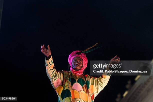 Performer dressed as Baltasar King waves to the crowd as he rides a float during the 'Cabalgata de Reyes,' or the Three Kings parade on January 5,...