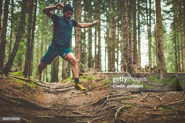 trail running in den wald: jumping wurzeln - trailrunning stock-fotos und bilder