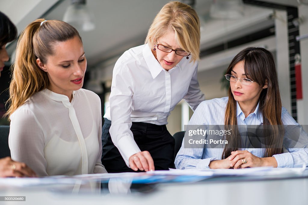 Manager explaining strategy to executives at desk