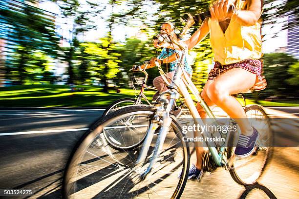reiten fahrräder im central park, new york - fun couple on bike stock-fotos und bilder
