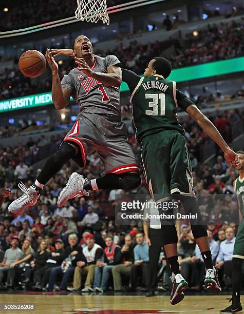 John Henson of the Milwaukee Bucks knocks the ball away from Derrick Rose of the Chicago Bulls at the United Center on January 5, 2016 in Chicago,...