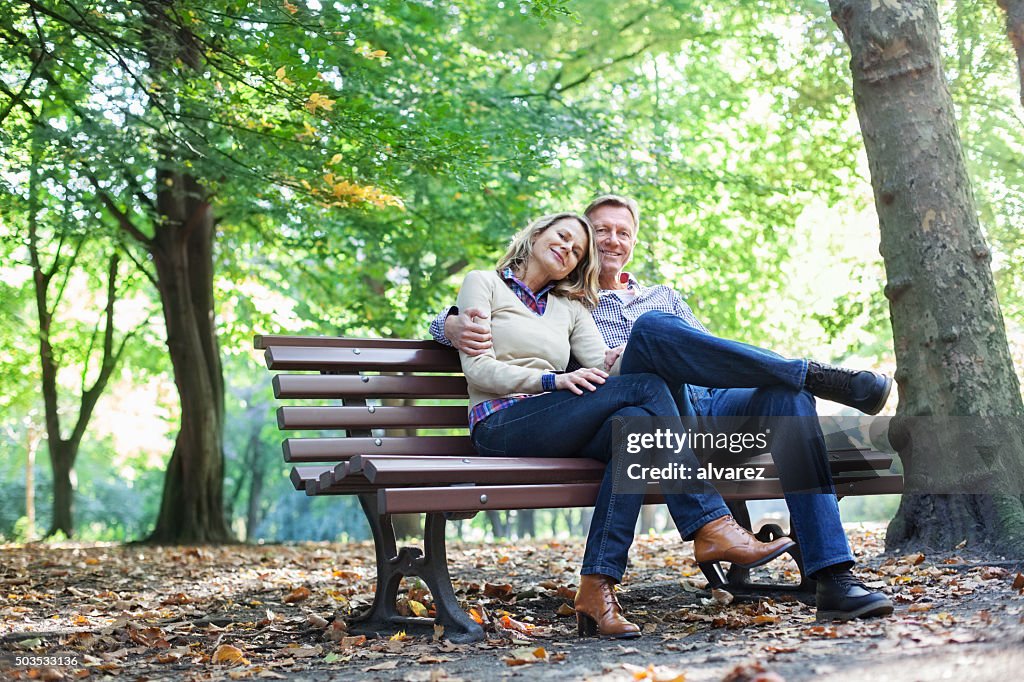 Zärtlich Paar sitzt auf einem park bench