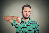 angry, unhappy man showing thumbs down sign