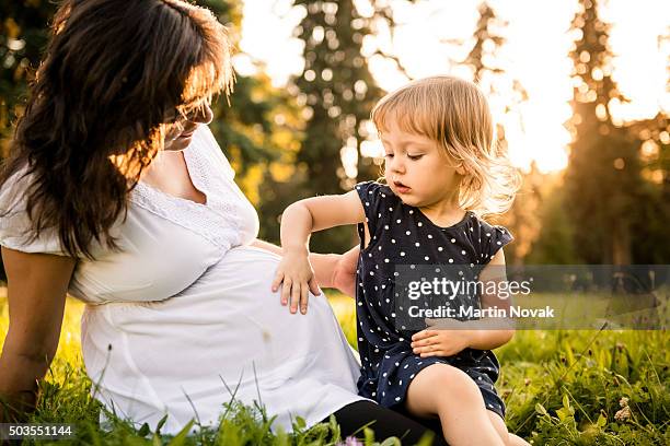 child sensing baby in belly - kids belly stock pictures, royalty-free photos & images