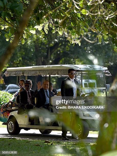 Pakistani Prime Minister Nawaz Sharif waves as he and his wife Kalsoom Nawaz Sharif ride in a buggy during a visit to The Peradeniya Royal Botanical...