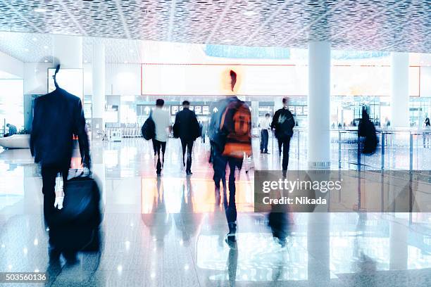 motion blurred travellers walking in modern airport hallway - tourist china stock pictures, royalty-free photos & images