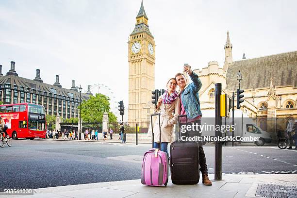 young tourist couple shoots selfie big ben london uk - couple london stockfoto's en -beelden