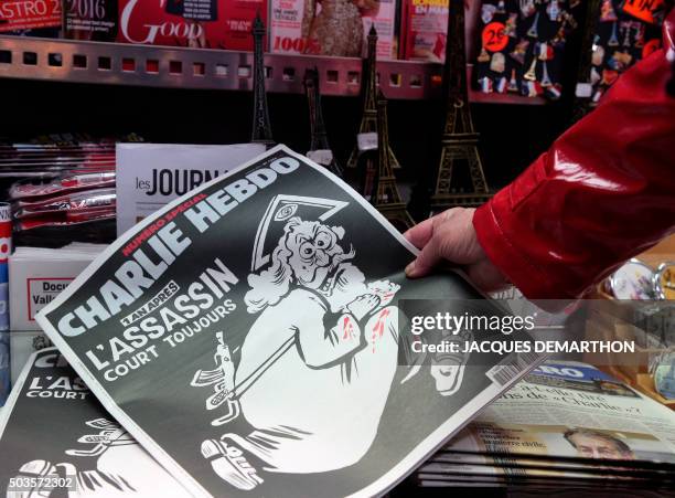 Woman looks at the special commemorative edition of French satirical newspaper Charlie Hebdo at a newsstand in Paris, on January 6 to mark the...